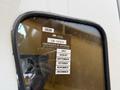 A close-up of a wet window on a Freightliner 108SD truck featuring a certificate of approval with a list of months and a numeric code