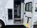 A 2016 Chevrolet Express with an open side door revealing steps and a section of interior storage space