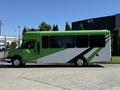 A green and white 2013 Chevrolet Express bus with large windows and seating capacity, designed for passenger transport