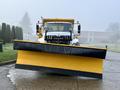A 2016 International 7400 truck equipped with a large yellow snow plow at the front