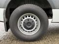 A close-up view of a wheel from a 2023 Mercedes-Benz Sprinter featuring a silver alloy rim and a black tire with distinct tread patterns