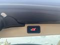 A 2009 BMW X5 interior button with a red car icon indicating the trunk release function