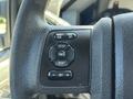 Close-up of control buttons on the steering wheel of a 2014 Ford F-250 SD including settings for info reset and cruise control