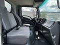 Interior of a 2016 Isuzu NQR showing gray fabric seats and a simple dashboard with steering wheel and controls