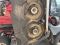 A close-up view of two circular mower blades attached to a Toro Groundmaster 5910 showcasing grass clippings on the blades