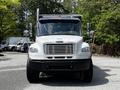 A front view of a 2010 Freightliner M2 106 truck with a white body and chrome grille showcasing its large headlights and side mirrors