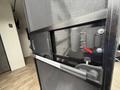 A close-up view of a door latch on a 2022 Keystone Hideout RDWE 20RDWE camper with a black handle and a red safety latch
