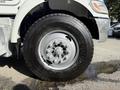 A close-up of the front wheel of a 2015 Peterbilt 337 featuring a metal rim with multiple lug nuts and a thick black tire with visible tread patterns