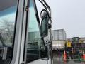 A 2012 Ford Econoline with a close-up view of its side mirror and door, featuring raindrops on the glass