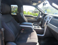 Interior view of a 2014 Ford F-150 showing the front seats and center console with a focus on fabric upholstery and dashboard elements