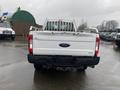 A 2017 Ford F-250 Super Duty pickup truck viewed from the rear with a white exterior and a metal bed rack