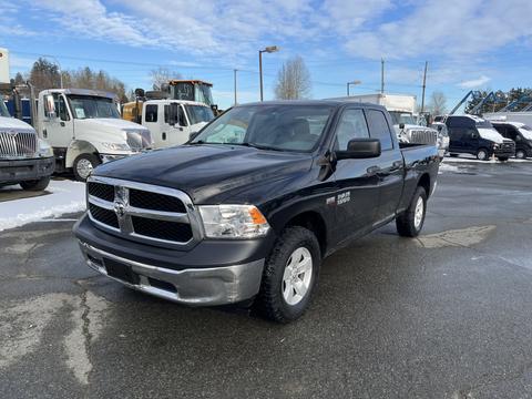 A black 2015 RAM 1500 pickup truck with a silver front bumper facing forward with a spacious cab and standard truck bed