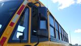 A yellow 2014 Freightliner Thomas Diesel school bus with large windows and side mirrors