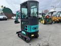A 2024 AGT Industrial Green QH13R Mini Excavator with a glass cabin and tracked undercarriage featuring controls on one side and an extended arm with a bucket attachment
