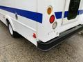 A 2015 Chevrolet Express van in white with blue stripes featuring a rear door and red taillights