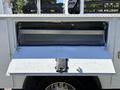 A 2016 Ford F-550 with an open storage compartment revealing an empty interior space designed for tools or equipment