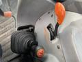 Close-up of the gear shift and controls of a 2016 New Holland T475 tractor with an orange lever and textured grip handle