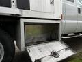 A metallic storage compartment of a 2014 Ford F-250 SD truck with an open door and a hook latch on the front