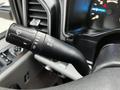 A close-up view of the turn signal and windshield wiper controls on the steering column of a 2016 Ford F-150