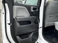 The interior door panel of a 2018 GMC Sierra 1500 featuring a gray and black design with a handle and storage compartment