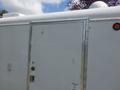A white 2004 Royal 18 Foot Office Trailer featuring a metal door with a small dent and a red signaling light on the side