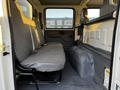 Interior of a 2017 Isuzu NPR showing a two-seat bench with gray upholstery and a simple floor design