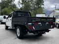 A white 2020 Ford F-350 SD with a black flatbed and a mesh back is parked with its rear facing the viewer