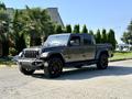 2021 Jeep Gladiator in a gray finish with black wheels showcasing a rugged design and a distinctive front grille