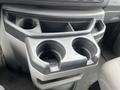 A gray cup holder console with two circular cup holders and a compartment in the middle ideal for storage in a 2010 Ford Econoline