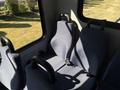 Interior view of a 2017 Chevrolet Express showcasing two blue fabric seats with black armrests and seatbelts