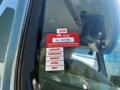 A 2000 Ford Motorhome displaying a bright red British Columbia certificate of approval sticker on the driver's side window with month labels for January to May
