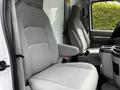 Interior of a 2021 Ford E-450 showing two gray fabric front seats and a central console with cup holders