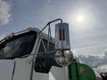A 1996 Kenworth T800 truck with a chrome side mirror and a red marker light reflecting sunlight