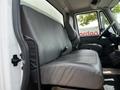 Interior view of a 2019 International 4300 truck featuring a large black vinyl bench seat and a driver's seat with armrests
