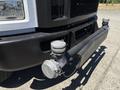 A 2019 Ford F-750 with a prominent front bumper featuring a large air compressor and a pipe attachment on one side