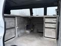 A 2016 GMC Savana interior with metal storage cabinets and drawers on the sides of the cargo area