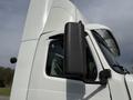 A white 2012 Volvo VNL semi-truck with a hanging black fuel tank and a large cab design