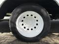 Close-up of a white wheel with a five-bolt pattern and a black tire mounted on a 2016 Ford Transit