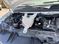 The image shows the engine compartment of a 2012 Chevrolet Express with visible components including the coolant reservoir battery and various hoses and cables