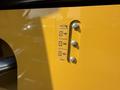 Close-up of a yellow gauge on a 2022 Caterpillar 306 displaying three fuel level indicators marked at 100 with metallic screws on the side