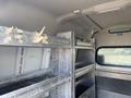 Interior of a 2013 Ford Transit Connect with metal shelving and remnants of tape on the walls