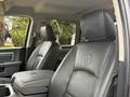 Interior of a 2018 RAM 1500 featuring leather seats with embossed RAM logo and a center console
