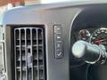 Close-up of the dashboard controls of a 2014 Chevrolet Express showing various buttons and a gear shift lever