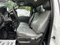 Interior view of a 2011 Ford F-550 showing two gray leather front seats and the driver's side dashboard with visible controls and a floor mat