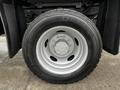 A close-up image of a wheel with a silver rim and black tire labeled with the brand and size details