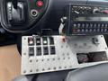 Control panel of a 2008 Mitsubishi Fuso FE180 featuring multiple switches and gauges for operating various functions and equipment