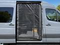 A 2017 Mercedes-Benz Sprinter van with a black mesh screen door open to the interior