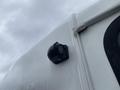 A black marker light mounted on the side of a white 2012 Chevrolet Express van