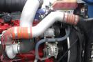 Close-up view of a 2015 Kenworth T660 engine showing various components including hoses a turbocharger and an alternator