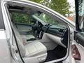 Interior view of a 2012 Toyota Camry showing the front seats and dashboard with leather upholstery and wood accents